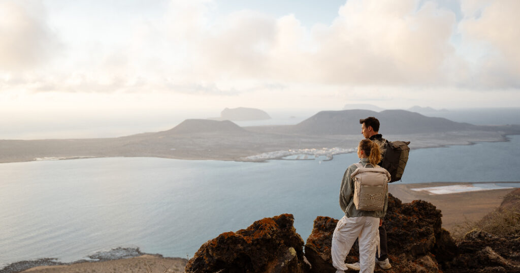 Frau und Mann blicken bei Backpacking Wanderung über das Meer