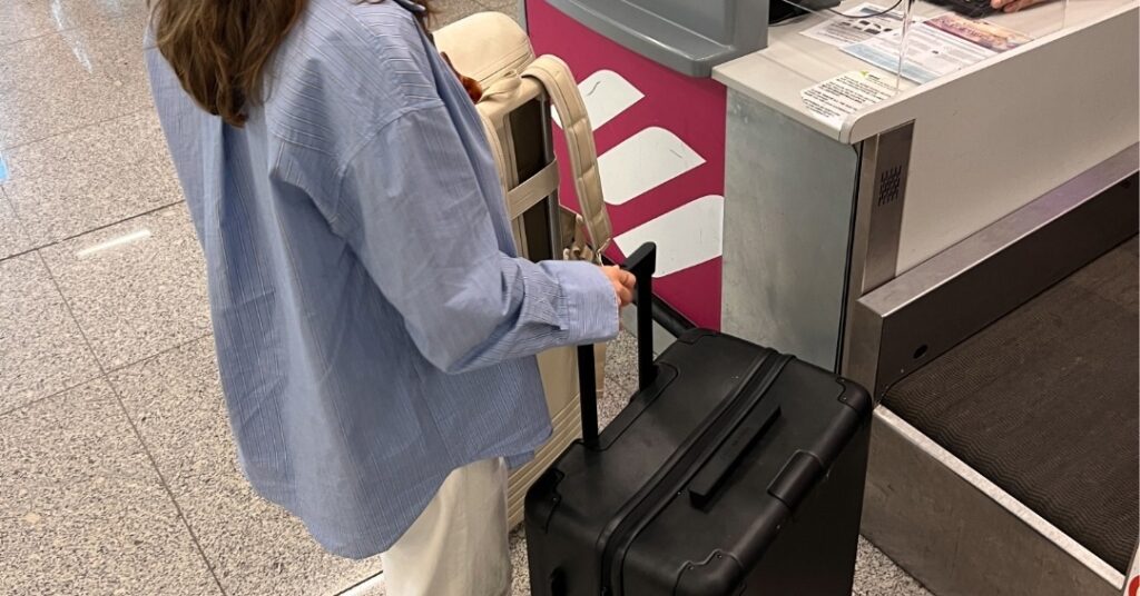 frau checkt kapten and son koffer ein